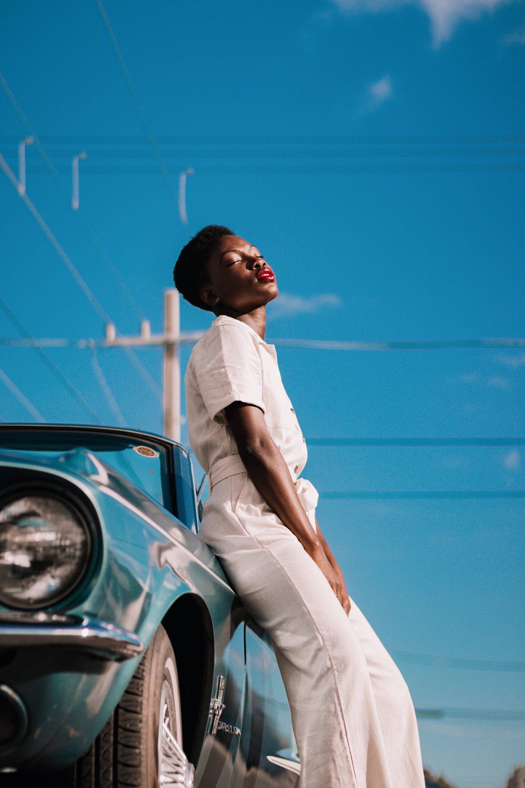 black woman in white on car